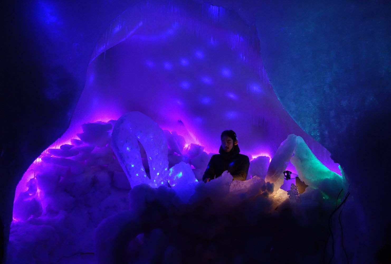 An ice igloo space lit in violet and blue